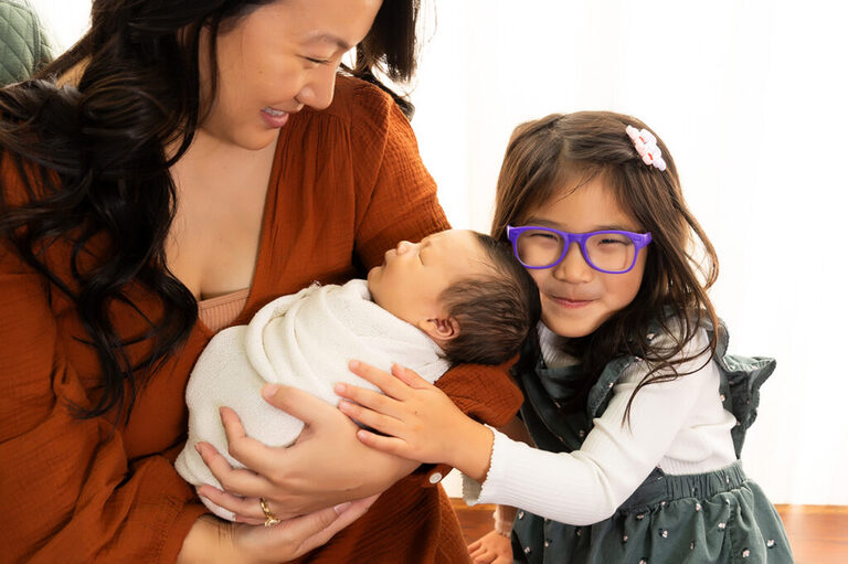 dallas newborn photographer taking photos with mom, baby and sister