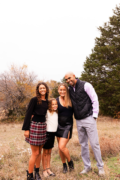 best north tx photographer taking family portraits at a field in Plano