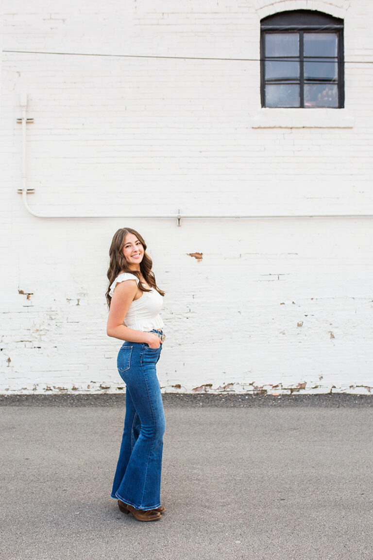 frisco senior photographer in front of a white building