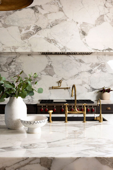 full marble kitchen with gold accents and luxury range interior design photoshoot