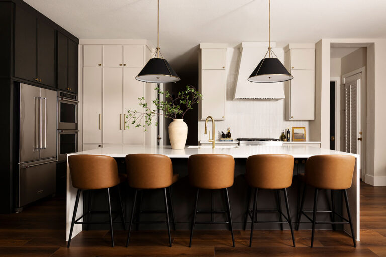 full shot of a luxury kitchen with custom marble waterfall countertops and light walls.