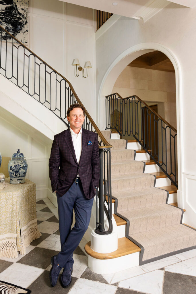 man standing in front of a luxury staircase