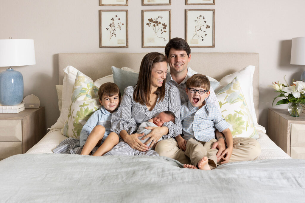 plano newborn photographer happy family on a bed