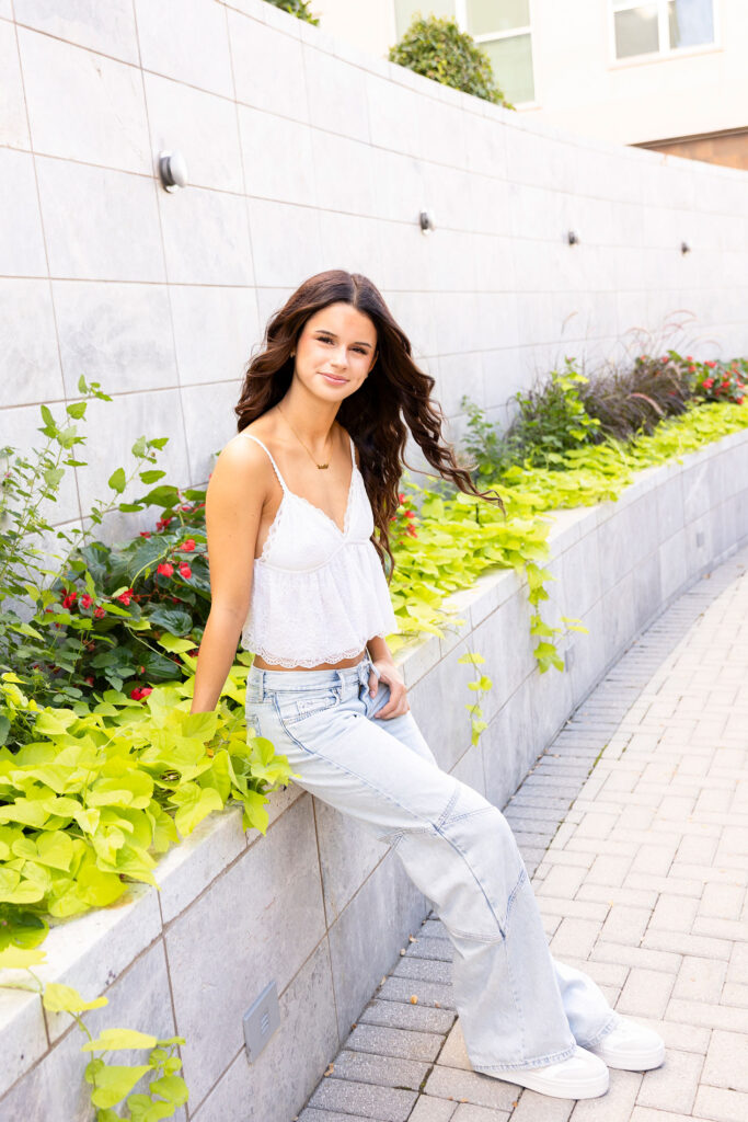 girl sitting on bench with greenery