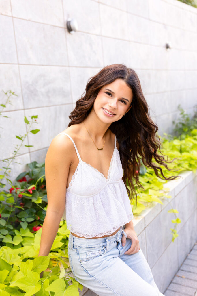 girl sitting on bench with plants