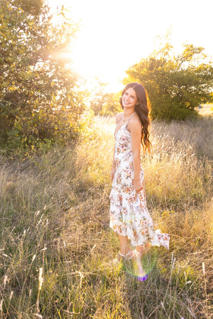 senior looking over her shoulder in a field