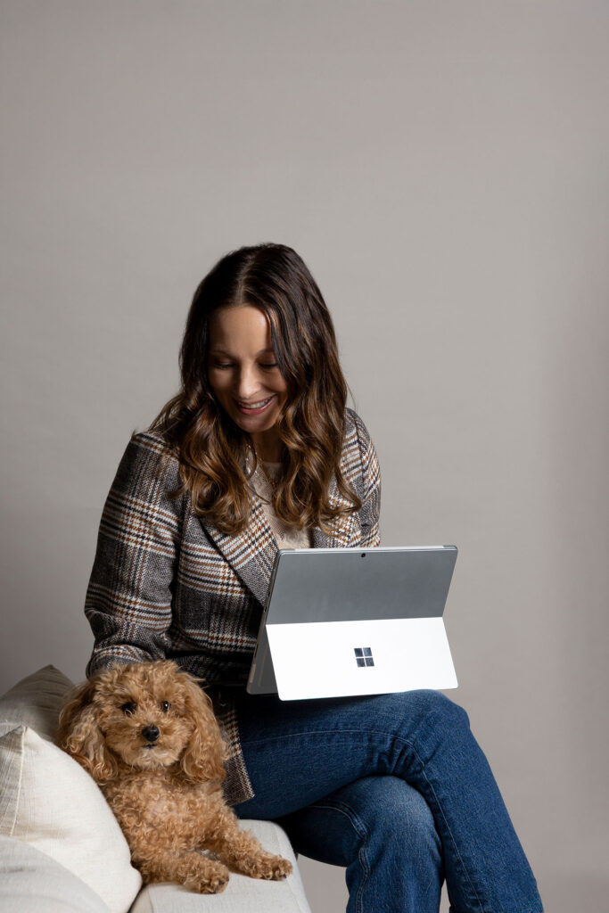 brand photographer working with laptop and dog