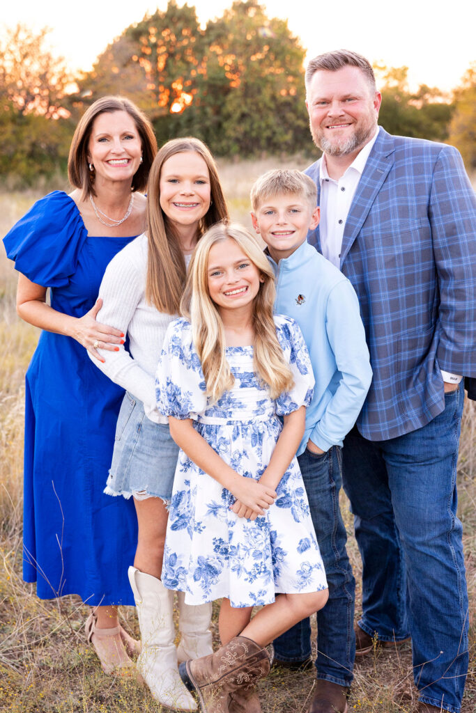 family of 5 in shades of blue in a field