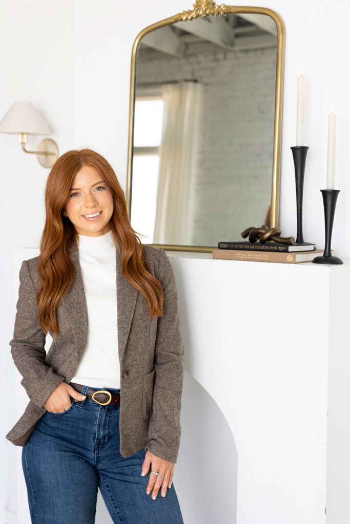designer smiling in front of a white mantel
